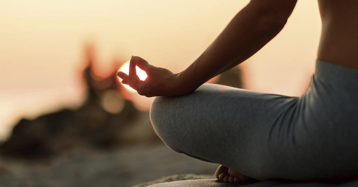 mujer practicando yoga al amanecer