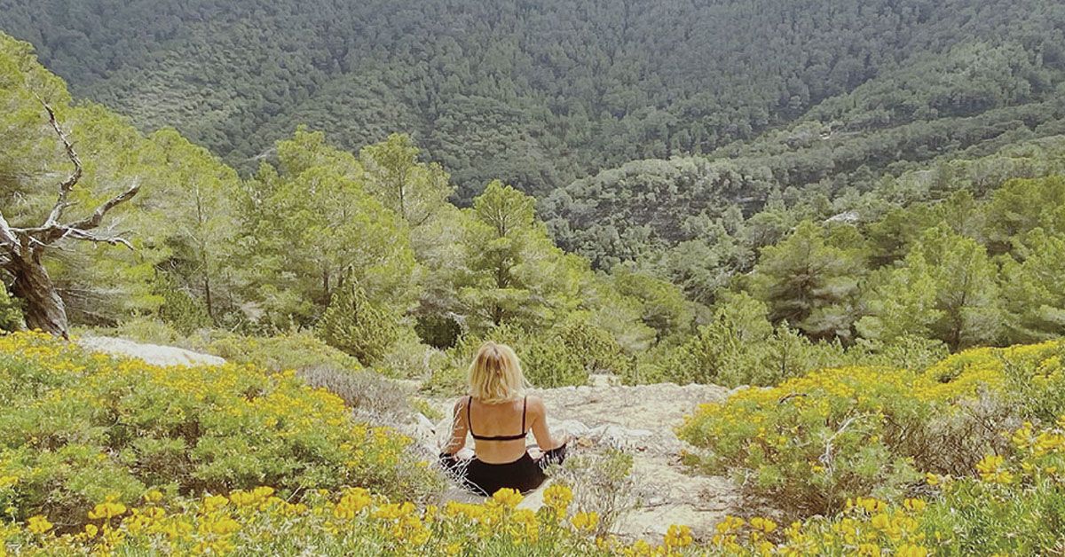 Mujer meditando en plena naturaleza de Ibiza